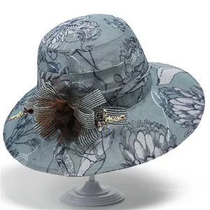 Dettaglio del cappello da sole a fiori blu con fiocco a righe e decorazione floreale