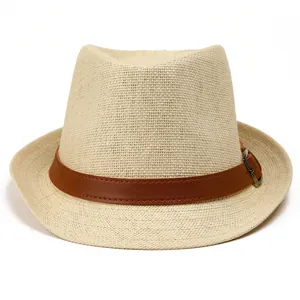 Detailed view of woven straw fedora hat with brown leather band and metal buckle