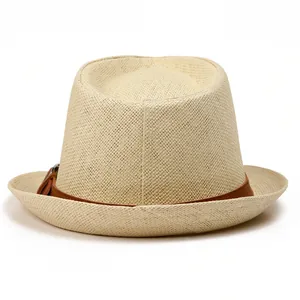 Close-up of woven straw fedora hat with a premium dark brown leather band and buckle