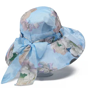 Detailed view of light blue wide brim sun hat with floral pattern and large silk bow