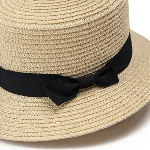 Detalle de la textura del sombrero de paja con un elegante lazo de cinta de grosgrain negro