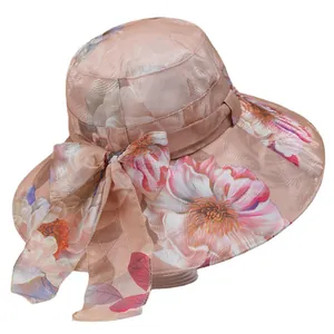 Women's wide brim sun hat with peach floral pattern and decorative ribbon bow