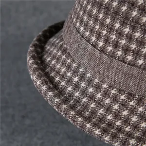 Detail of vintage houndstooth wool fabric texture and stitching on a warm bucket hat