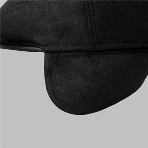 Detail of wool blend ear protection flap with quality stitching on black winter cap
