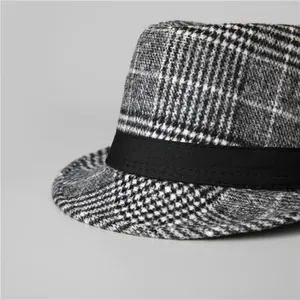 Macro detail of classic black and white checkered wool fedora with black decorative band