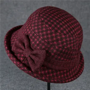 Detailed view of red and black houndstooth wool hat with a decorative bow embellishment