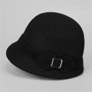 Close-up of elegant black wool cloche hat featuring a decorative rhinestone buckle detail