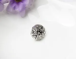Macro d'une perle étoile de mer argentée avec texture vintage pour bracelets DIY
