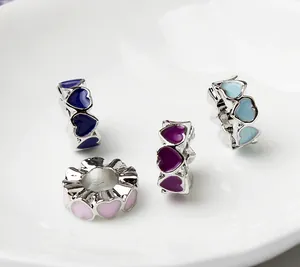 Macro view of colorful heart-shaped enamel beads with silver finish for DIY jewelry