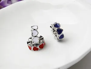 Macro detail of heart-shaped enamel beads for jewelry making in red, white and blue