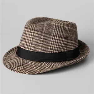Close-up of brown houndstooth wool fabric texture and black ribbon on vintage fedora hat