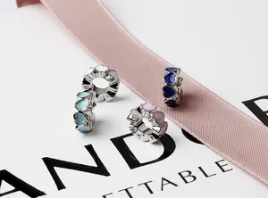 Close-up of enamel heart charms in white, blue, and pink on silk ribbon gift display