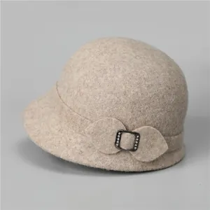 Detail of wool cloche hat showing leaf-shaped decor and rhinestone metal buckle