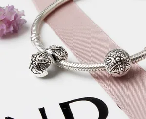 Gros plan sur un bracelet en maille serpent argentée avec breloques à motifs d'étoiles