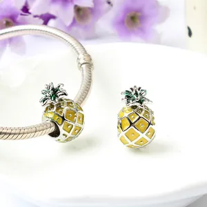 Macro shot of pineapple charm bead with yellow enamel and silver mesh on snake chain