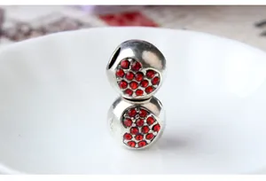 Vue macro de breloques sphériques argentées avec cœurs en strass rouges pour bijoux