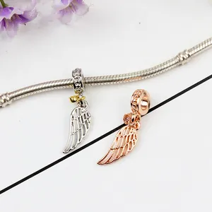 Detail of silver and rose gold angel wing charms on a snake chain with crystal accents