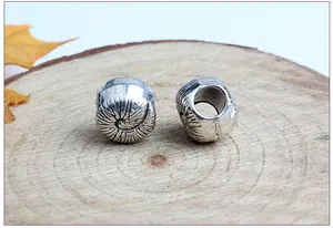 Detailed view of snail-shaped silver alloy large hole beads with spiral texture