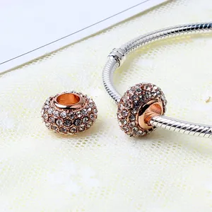 Macro shot of rose gold large-hole charms with cubic zirconia on a snake chain bracelet