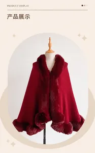 Detailed close-up of luxurious red faux rabbit fur trim on a winter knit poncho cape