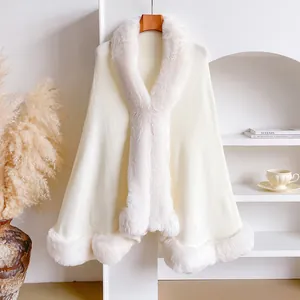 Detailed view of the soft faux rabbit fur collar on a beige knit winter poncho cloak