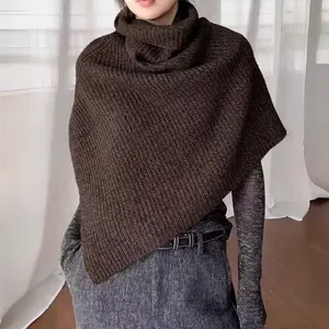 Detailed knit texture of dark brown turtleneck poncho scarf with ribbed split hem design