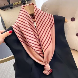 Detailaufnahme eines rosa-burgunder gestreiften Seidenschals, gebunden an einem schwarzen Top