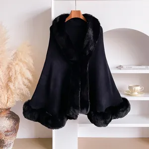 Detailed close-up of luxurious black faux fur collar on a winter knit cape shawl jacket