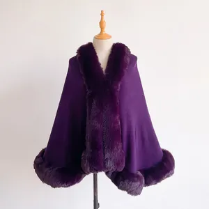Detail of dark purple wool cape featuring luxurious faux fur trim on the collar and hemline