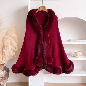 Detail of burgundy knit poncho showing the plush faux fur trim and soft fabric texture