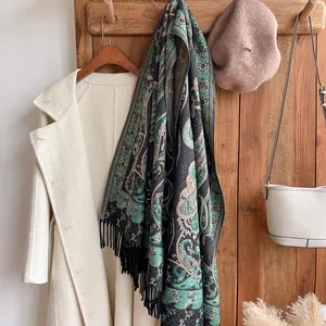 Détail du motif paisley sur un châle avec des franges noires sur un cintre en bois rétro