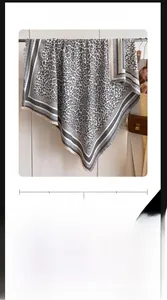 Detail of grey leopard print cotton scarf showing retro texture and fringe edges