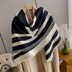 Detail of classic black and white striped cashmere shawl with fringe on beige coat