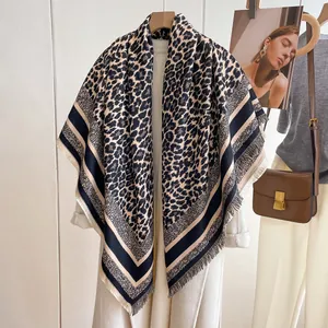 Close-up of leopard print scarf with striped borders and delicate tassel fringe details