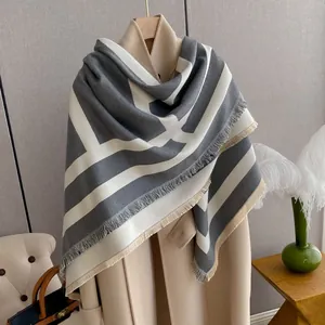 Close-up of thick geometric patterned scarf with fringe detail on cashmere-like fabric