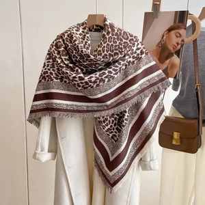 Detail of leopard print scarf with fringe edges draped over a white wool coat