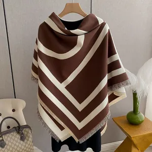 Close-up of brown and beige geometric cashmere shawl with elegant fringe details