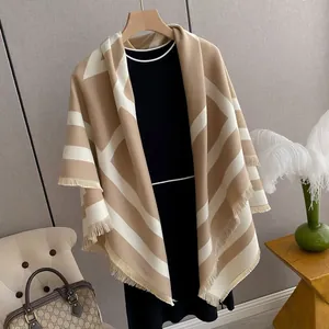 Detail of beige cashmere-style shawl with fringe trim and elegant geometric pattern
