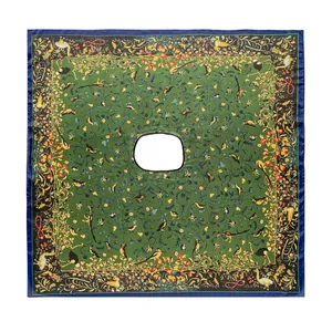 Détail d'un poncho en soie verte avec des motifs complexes de fleurs et d'oiseaux imprimés