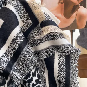 Close-up of leopard and houndstooth patterned thick scarf with soft cream fringe edges