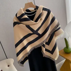 Detail of beige cashmere-like shawl with black stripes and soft fringe tassels