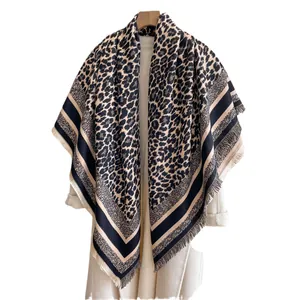Thick leopard print cashmere scarf with tassel edges on a white coat background