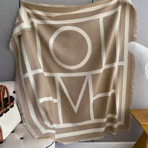 Beige and white thick cashmere feel scarf with HOME letter pattern and fringe details