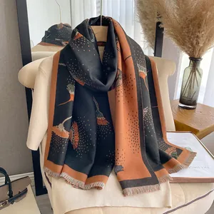 Close-up of caramel and black scarf with ginkgo leaf patterns and soft fringe detail