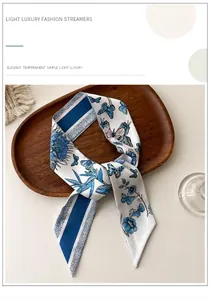 Détail d'un ruban en soie avec imprimé floral et papillon sur un plateau en bois