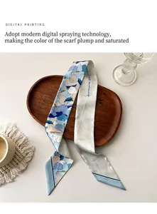 Détail du foulard en soie avec imprimés hibiscus bleus et pointes diagonales