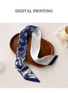 Detail of a dual-sided skinny scarf with navy paisley print and grey checkered patterns