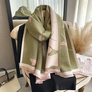 Close-up of dandelion pattern scarf with soft tassels in olive and pink shades