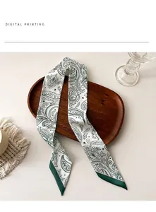 Detalle del estampado paisley digital en un pañuelo de seda blanco con borde verde