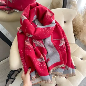 Detail view of red cashmere feel scarf with grey floral patterns and fringe edges